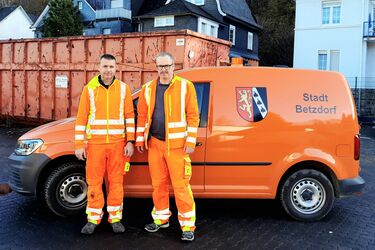 Stellervertretender Bauhofsleiter Peter Diedershagen und Bauhofsleiter Christoph Hebel stehen vor dem Bauhofsfahrzeug.
