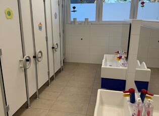 Waschraum mit 2 zwei Waschbecken und mehreren Kabinen mit Toiletten