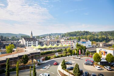Blick über den Kreisel und den Parkplatz in der Wilhelmstraße, im Hintergrund die Fußgängerbrücke und der Busbahnhof